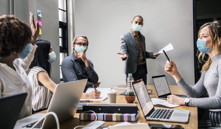 Business people wearing masks in coronavirus meeting, the new no