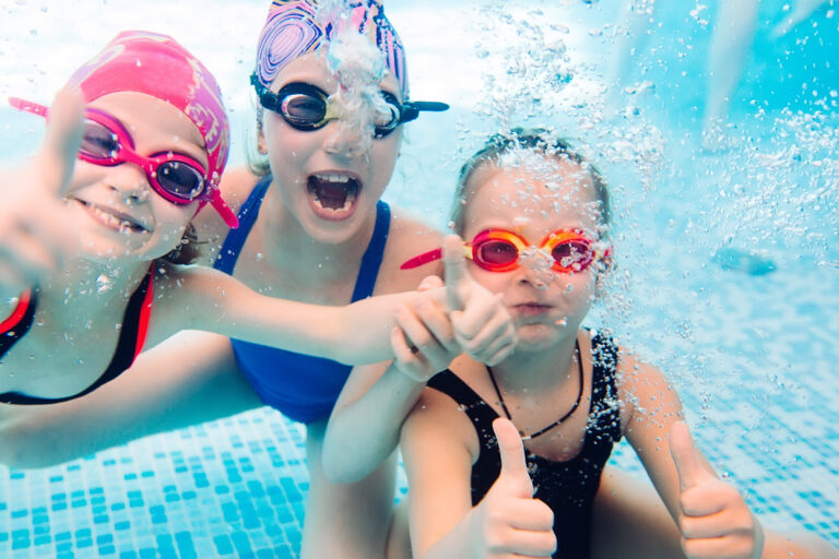 Underwater photo of young friends in swimming pool